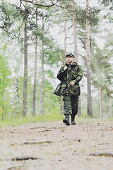 Image showing young soldier or hunter with gun in forest