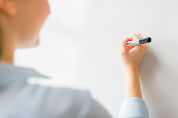 Image showing close up of woman writing something on white board