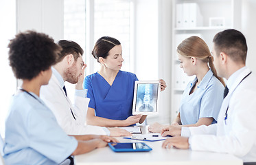 Image showing group of doctors with x-ray on tablet pc at clinic