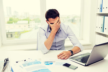 Image showing businessman with laptop and papers in office