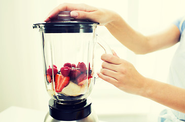 Image showing close up of woman with blender making fruit shake