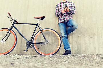 Image showing close up of hipster man with smartphone and bike