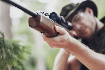 Image showing soldier or hunter shooting with gun in forest