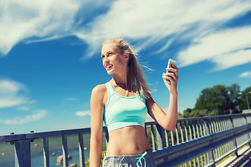 Image showing happy woman with smartphone exercising outdoors