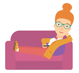 Image showing Woman sitting on the couch with remote control.