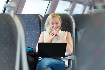 Image showing Woman smiling while travelling by train.