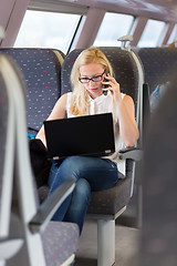 Image showing Business woman working while travelling by train.