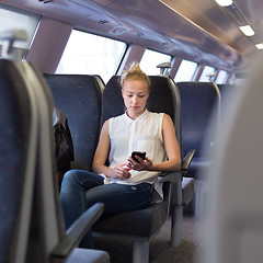 Image showing Woman using mobile phone while travelling by train.