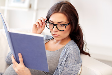 Image showing pregnant woman reading book at home