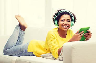 Image showing happy african woman with tablet pc and headphones