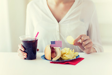 Image showing close up of woman eating chips, hot dog and cola