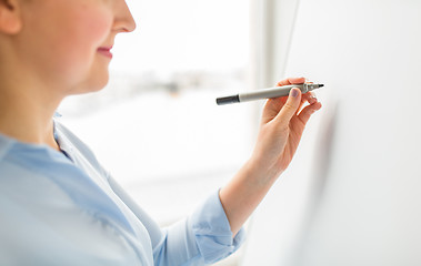 Image showing close up of woman writing something on white board