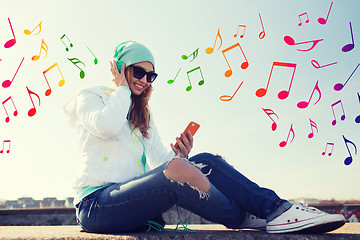 Image showing happy young woman with smartphone and headphones