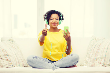 Image showing happy african woman with smartphone and headphones