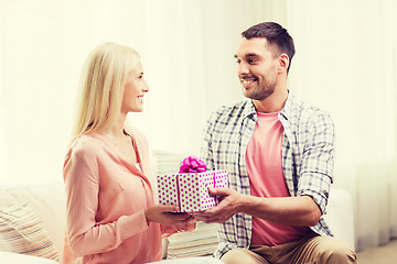 Image showing happy man giving woman gift box at home