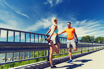 Image showing smiling couple stretching outdoors