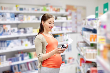 Image showing happy pregnant woman with medication at pharmacy