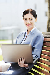 Image showing smiling business woman with laptop in city