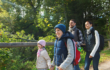 Image showing happy family with backpacks hiking in woods