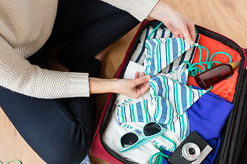 Image showing close up of woman packing travel bag for vacation