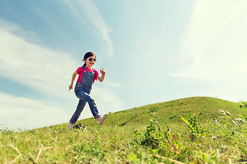 Image showing happy little girl running on green summer field