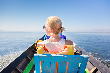 Image showing Female tourist travels by traditional boat.