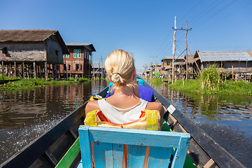 Image showing Female tourist travels by traditional boat.