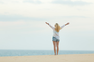 Image showing Free woman enjoying freedom on beach at dusk.