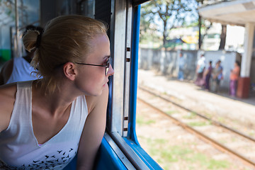 Image showing Young female adventurer traveling by train in Asia.