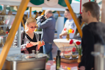 Image showing Woman buying meal at street food festival.