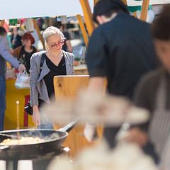 Image showing Woman buying meal at street food festival.