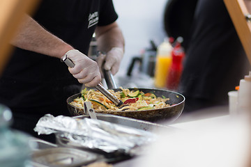 Image showing Cheff cooking on outdoor street food festival.