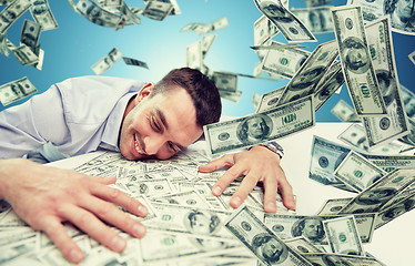 Image showing happy businessman with heap of money