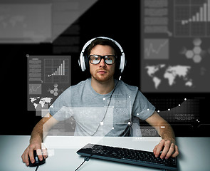 Image showing man in headset with computer over virtual screens