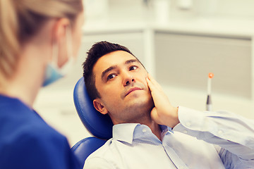 Image showing female dentist and male patient with toothache