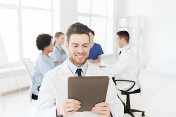 Image showing happy doctor with tablet pc over team at clinic