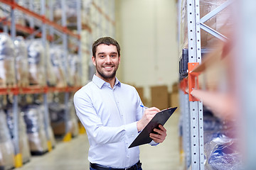 Image showing happy businessman with clipboard at warehouse