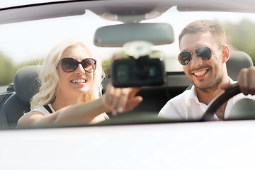 Image showing happy couple usin gps navigation system in car