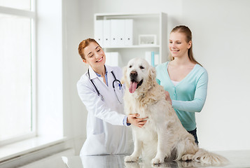 Image showing happy woman with dog and doctor at vet clinic