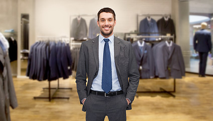 Image showing happy young businessman over clothing store