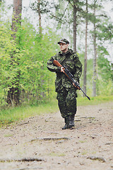 Image showing young soldier or hunter with gun in forest