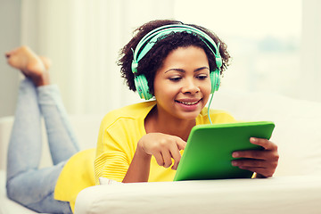 Image showing happy african woman with tablet pc and headphones