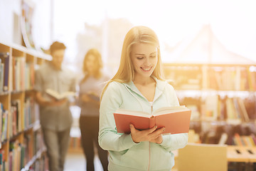 Image showing happy student girl or woman with book in library