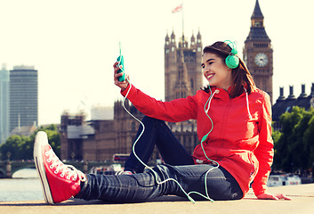 Image showing happy young woman with smartphone and headphones