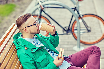 Image showing happy young hipster man with coffee and sandwich