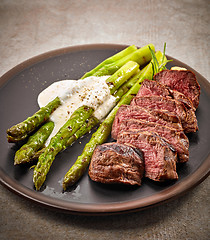 Image showing portion of sliced beef steak and asparagus