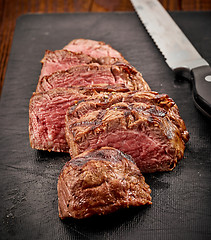 Image showing grilled sliced beef steak and knife