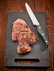 Image showing grilled sliced beef steak and knife