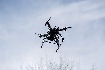 Image showing flying drone with camera on the sky