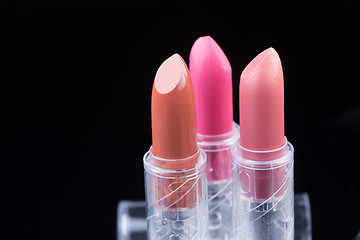 Image showing bright lipsticks on a black background